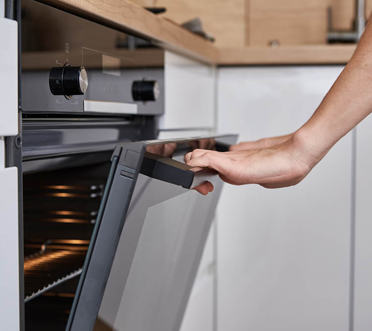 Woman hand open electric oven door with handle. Homemade cooking. Kitchen appliance