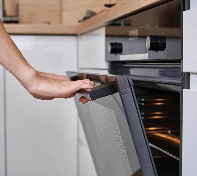 Woman hand open electric oven door with handle. Homemade cooking. Kitchen appliance